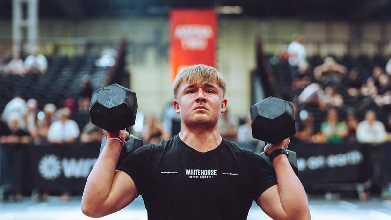 VOLT Person performing a squat exercise with dumbbells in a gym setting